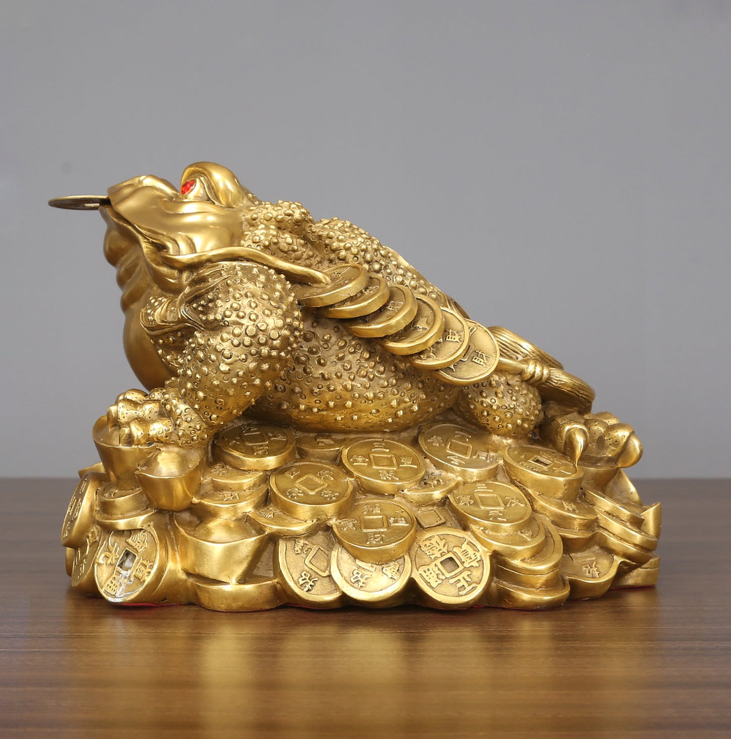 Side profile of a large hollow brass Feng Shui three-legged toad showing intricate craftsmanship and prosperity symbol
