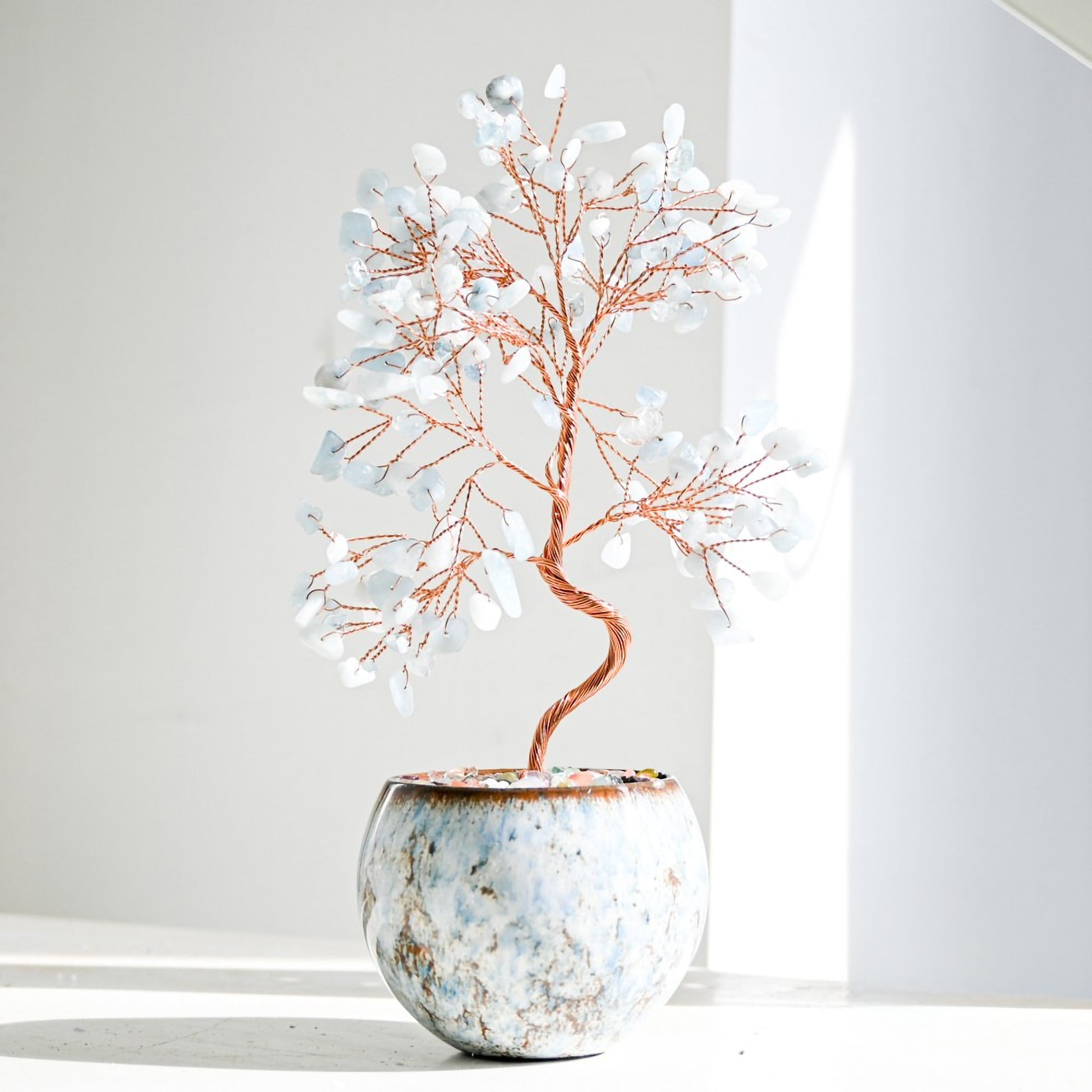 Aquamarine Feng Shui crystal money tree with delicate copper branches, placed in a tall ceramic pot with polished gemstones for calmness, clarity, and peaceful home energy