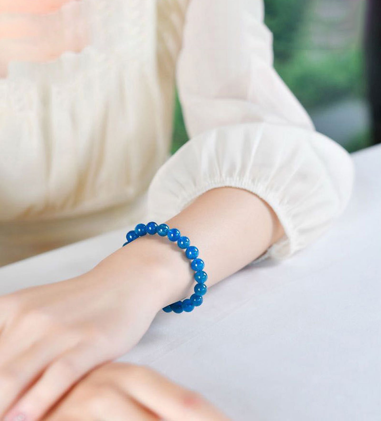 Woman wearing natural blue apatite crystal bracelet with 8mm beads, stylish healing stone jewelry