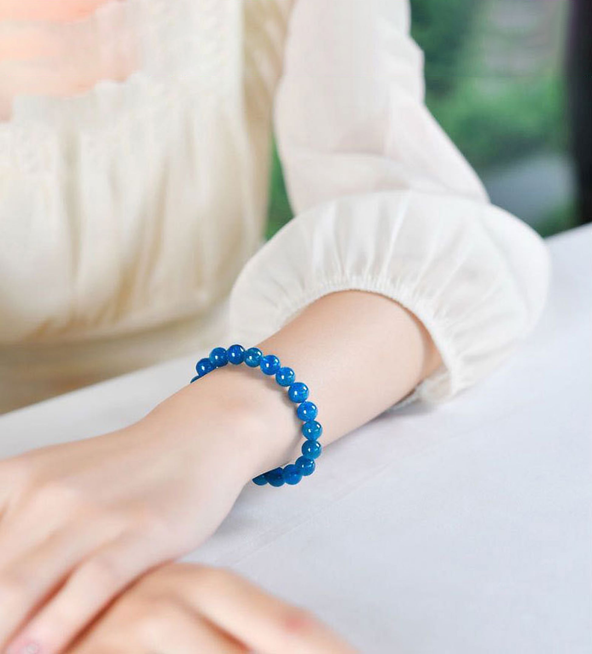 Woman wearing natural blue apatite crystal bracelet with 8mm beads, stylish healing stone jewelry