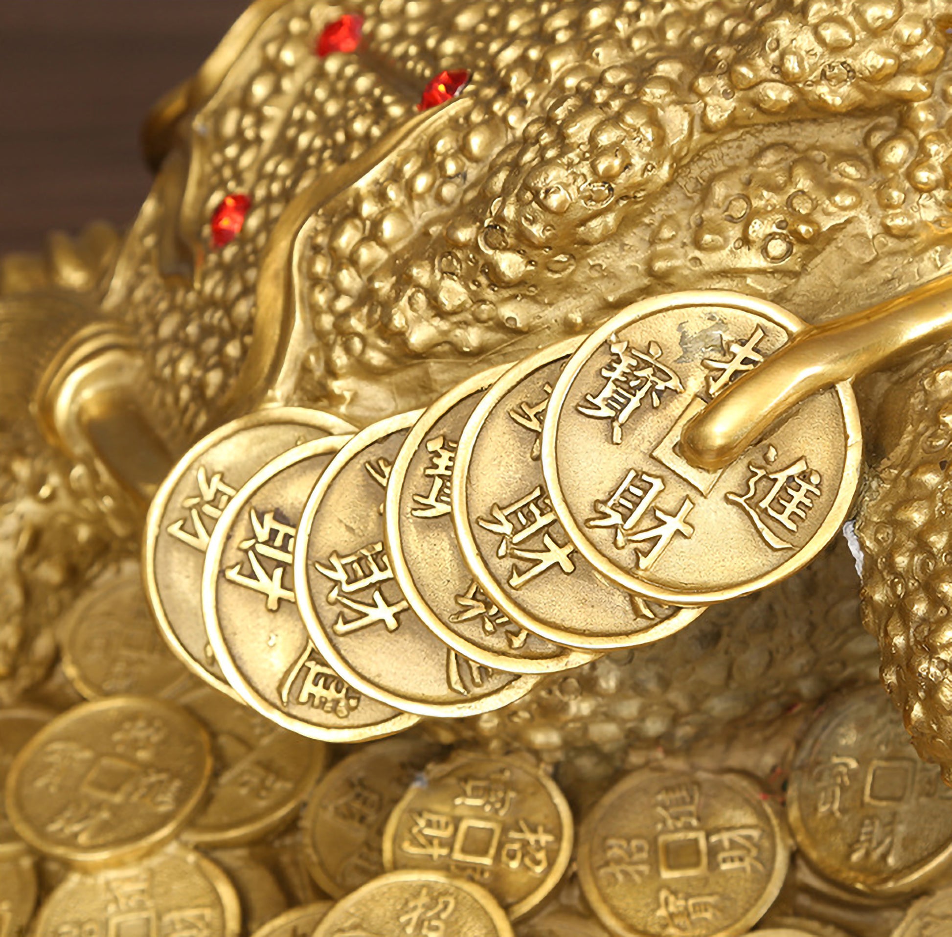 Close-up of the back and side details of a large hollow brass Feng Shui three-legged toad figurine with coin engravings