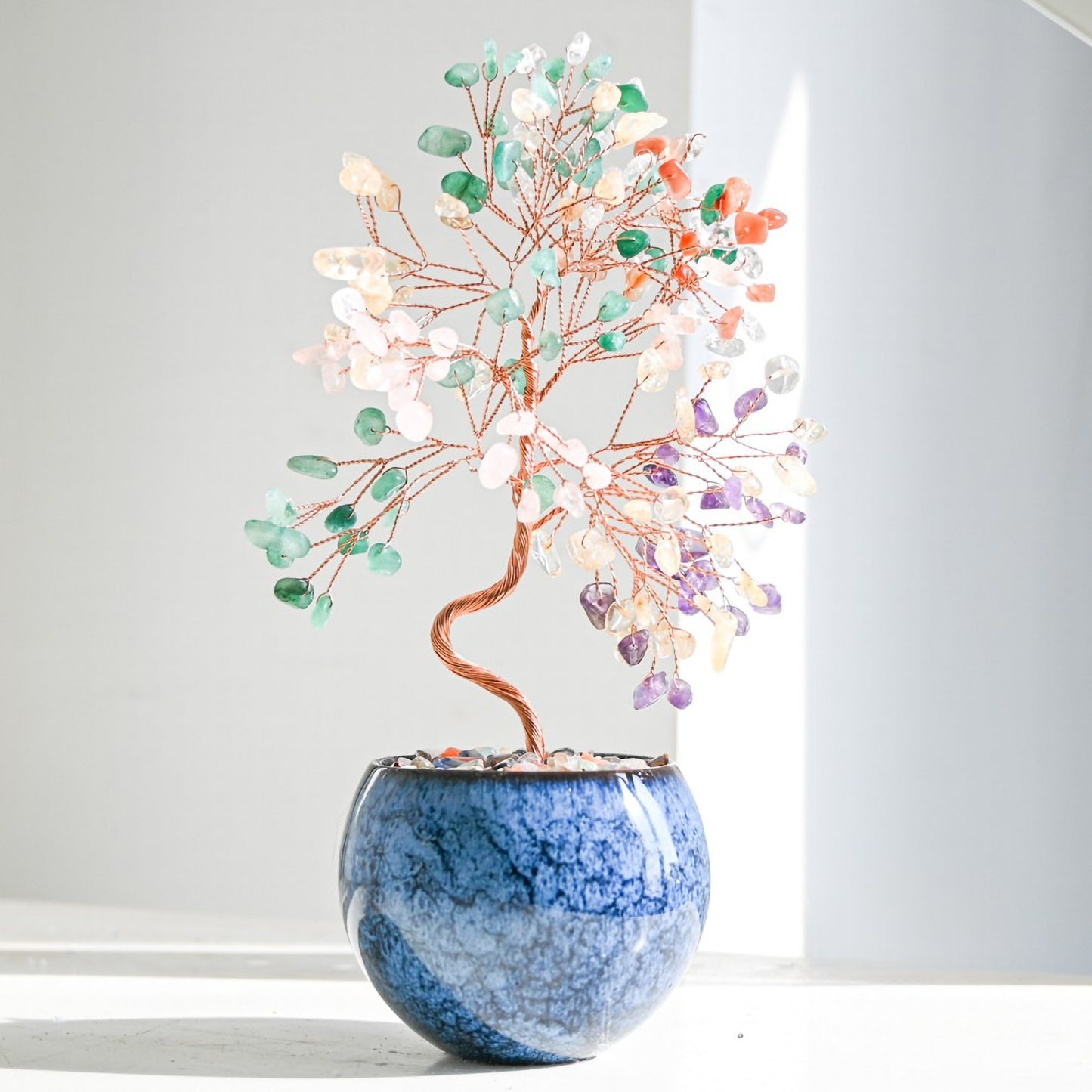 Multicolor Feng Shui crystal money tree with rainbow gemstones on copper branches, displayed in a tall pot with polished agate stones for chakra balance, vibrant energy, and home prosperity