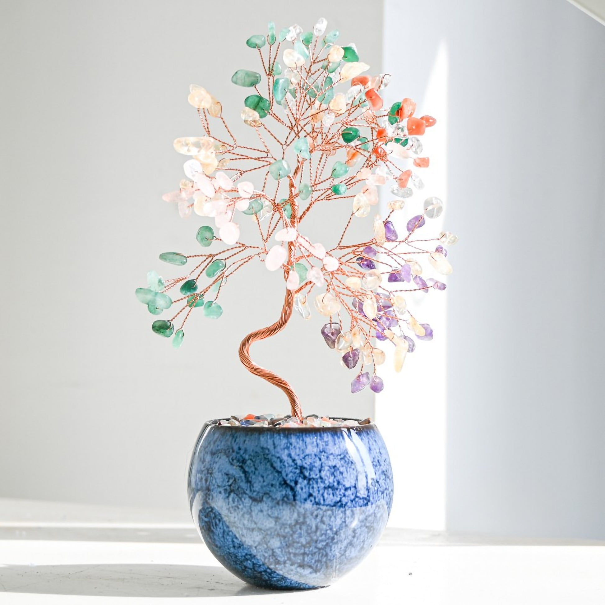 Multicolor Feng Shui crystal money tree with rainbow gemstones on copper branches, displayed in a tall pot with polished agate stones for chakra balance, vibrant energy, and home prosperity